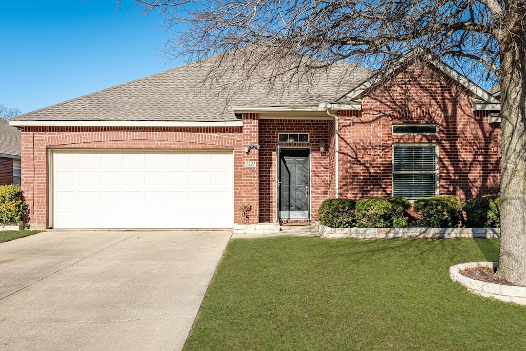 view of front of home with a front lawn and a garage