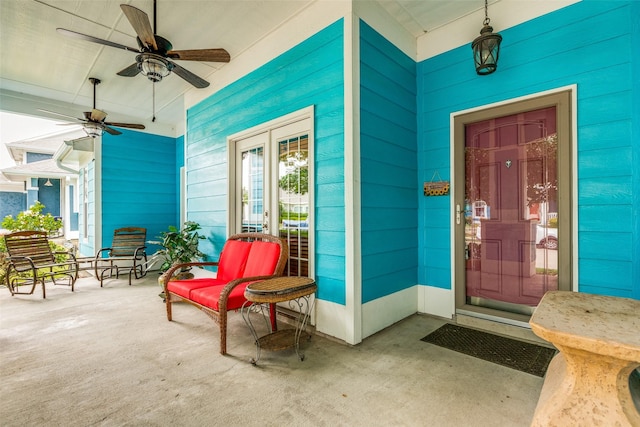 view of exterior entry featuring covered porch and ceiling fan