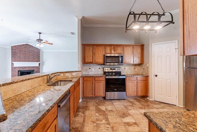 kitchen featuring appliances with stainless steel finishes, ceiling fan, a brick fireplace, sink, and backsplash