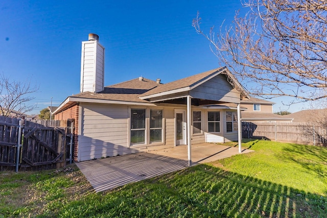 rear view of house with a lawn and a patio