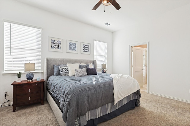 bedroom featuring light carpet, connected bathroom, and ceiling fan