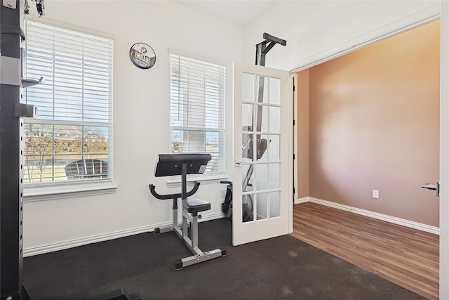 workout area with plenty of natural light and dark wood-type flooring