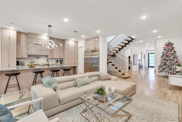 living room with light wood-type flooring and sink