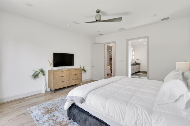 bedroom featuring ceiling fan, light hardwood / wood-style flooring, and ensuite bath