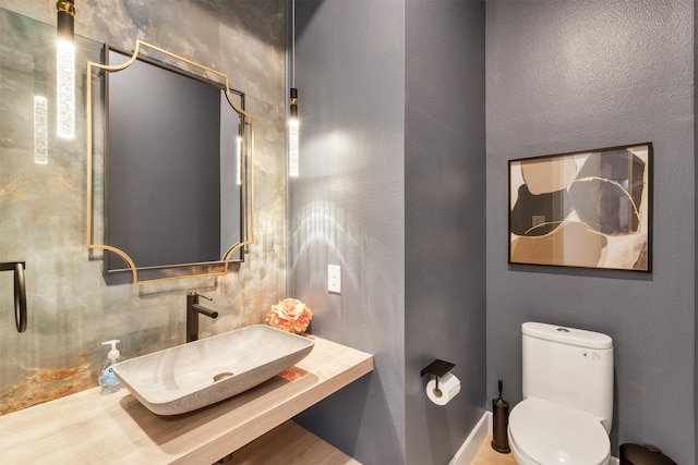 bathroom featuring sink, toilet, and hardwood / wood-style flooring