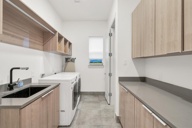 washroom featuring sink, cabinets, and separate washer and dryer