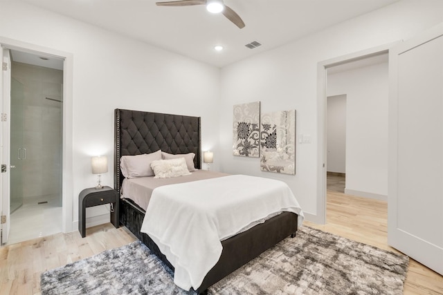 bedroom featuring ceiling fan, light wood-type flooring, and ensuite bath