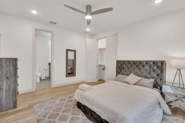 bedroom featuring ensuite bath, ceiling fan, light hardwood / wood-style flooring, and a closet