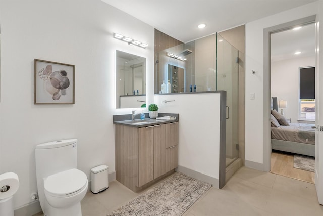 bathroom featuring toilet, walk in shower, tile patterned floors, and vanity