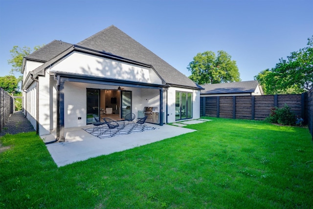 back of house with a patio area and a yard