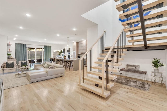 staircase with wood-type flooring and a chandelier