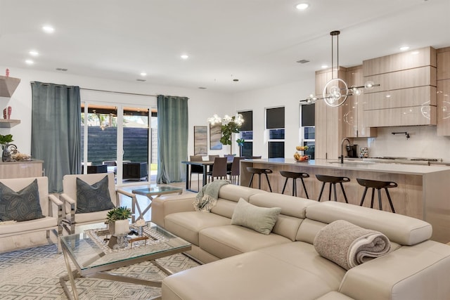 living room featuring sink and a notable chandelier