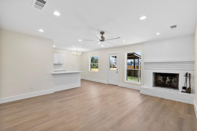 unfurnished living room with a fireplace, ceiling fan, and light hardwood / wood-style floors