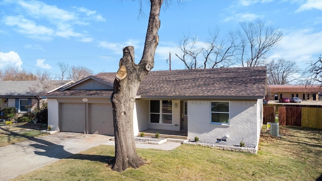 ranch-style house featuring central AC, a front lawn, and a garage