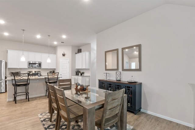 dining area featuring light wood finished floors, baseboards, and recessed lighting