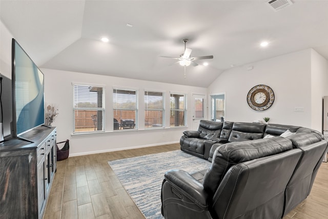 living room featuring light wood finished floors, visible vents, vaulted ceiling, and a ceiling fan