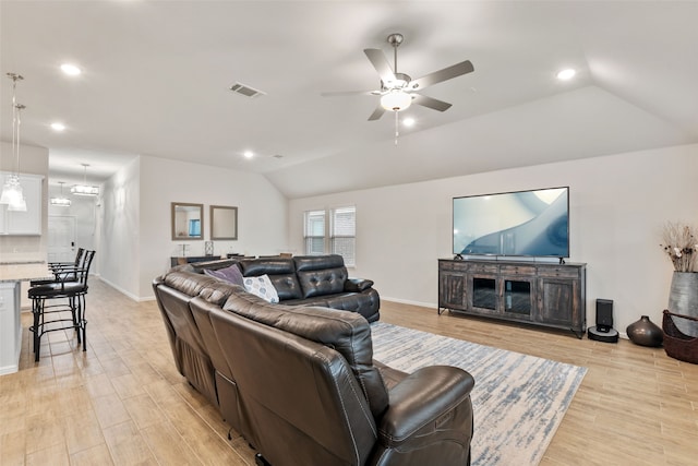 living room featuring lofted ceiling, light wood-type flooring, visible vents, and recessed lighting