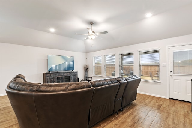 living room with light wood finished floors, ceiling fan, baseboards, and vaulted ceiling