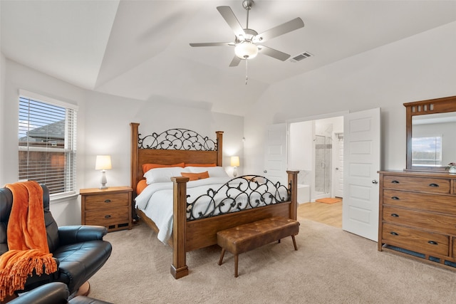 bedroom with lofted ceiling, connected bathroom, light colored carpet, a ceiling fan, and visible vents