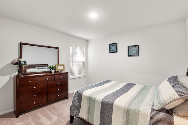 bedroom featuring baseboards and light colored carpet