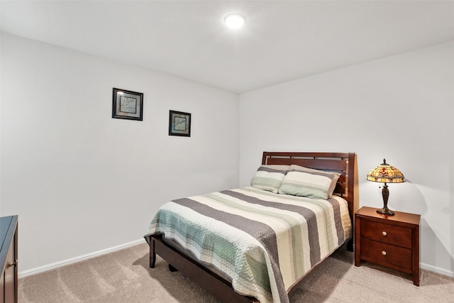 bedroom featuring light carpet and baseboards