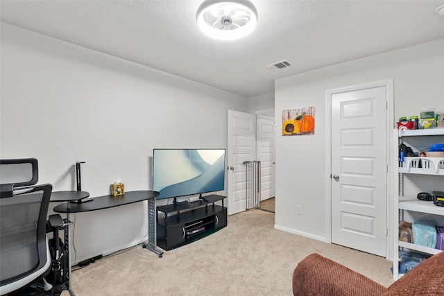 carpeted office space featuring visible vents, a textured ceiling, and baseboards