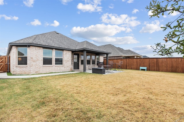 rear view of house featuring a patio area, a fenced backyard, a lawn, and brick siding