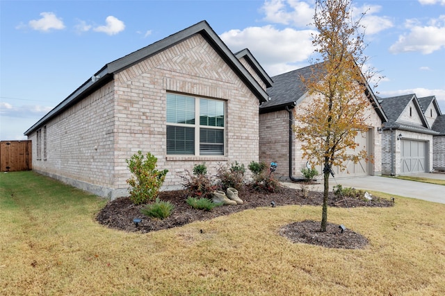 view of front of house featuring brick siding, a front yard, fence, a garage, and driveway