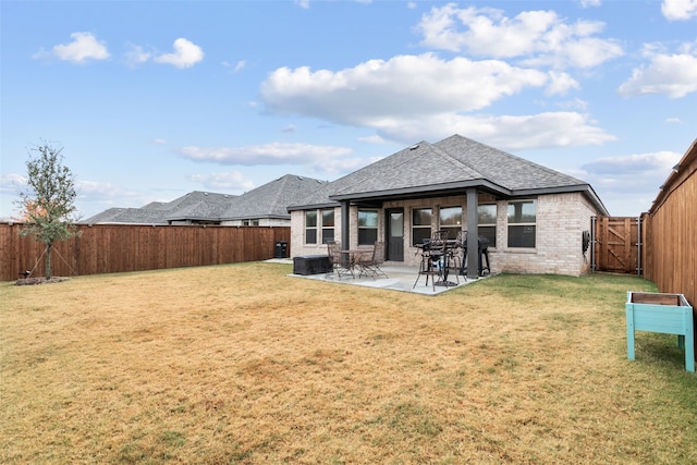 back of property featuring a lawn, a fenced backyard, a gate, a patio area, and brick siding