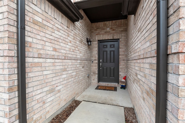 doorway to property featuring brick siding