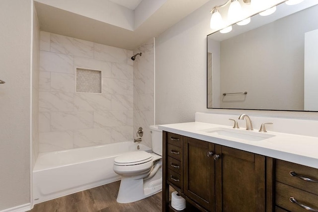 full bathroom with toilet, tiled shower / bath, wood-type flooring, and vanity