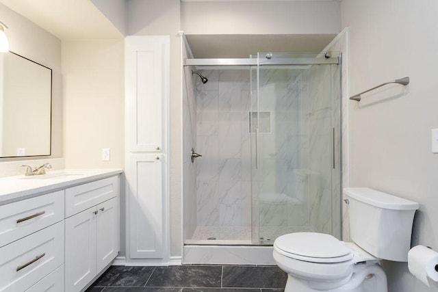 bathroom featuring a shower with door, vanity, and toilet