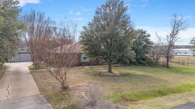 view of property hidden behind natural elements with a front yard