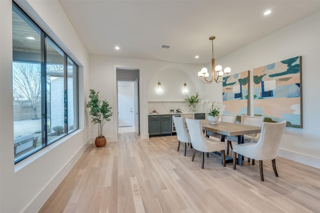 dining area featuring light wood-type flooring and a chandelier