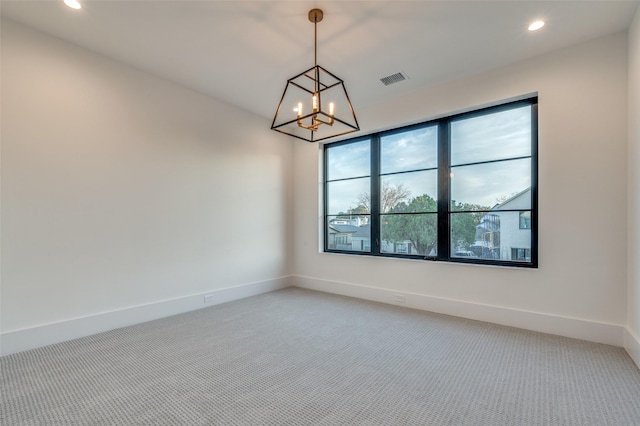 unfurnished room featuring an inviting chandelier and carpet floors