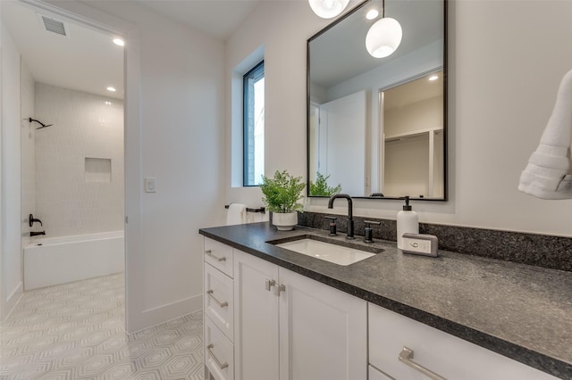 bathroom featuring vanity, tile patterned floors, and tiled shower / bath combo