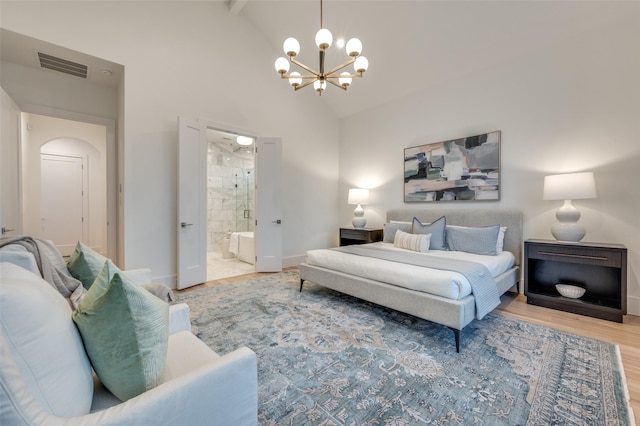 bedroom with beamed ceiling, hardwood / wood-style floors, high vaulted ceiling, ensuite bath, and a notable chandelier