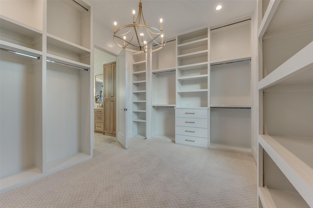 walk in closet with an inviting chandelier and light carpet