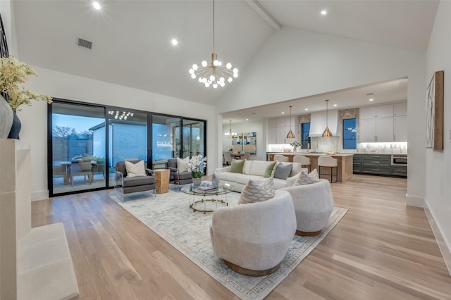 living room with beamed ceiling, light hardwood / wood-style flooring, high vaulted ceiling, and a chandelier