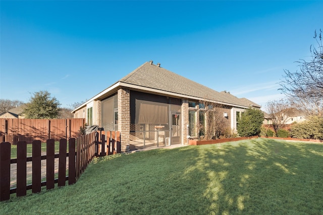 rear view of house featuring a yard