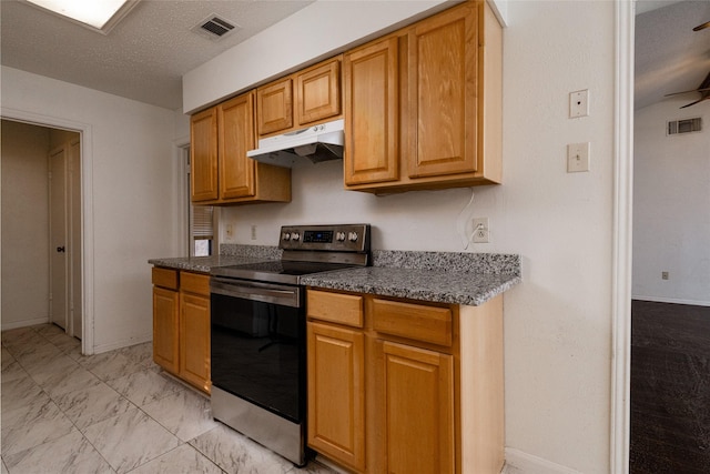 kitchen with stainless steel range with electric stovetop and a textured ceiling