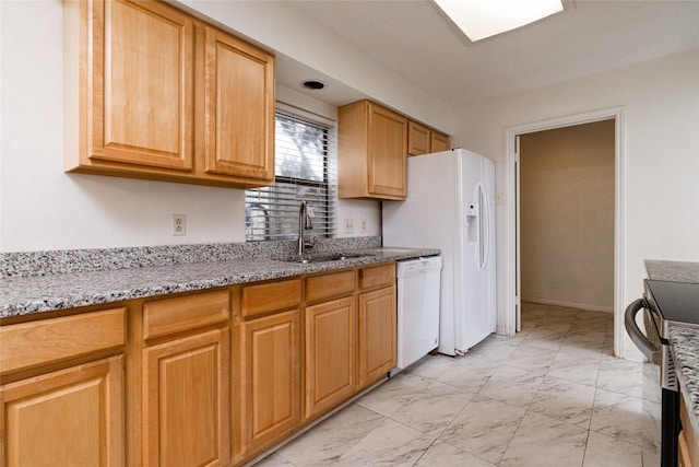 kitchen featuring white appliances, light stone counters, and sink