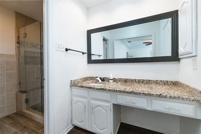 bathroom featuring wood-type flooring, walk in shower, and vanity