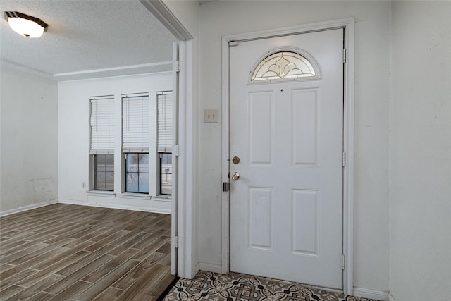 foyer entrance featuring a textured ceiling and dark hardwood / wood-style flooring