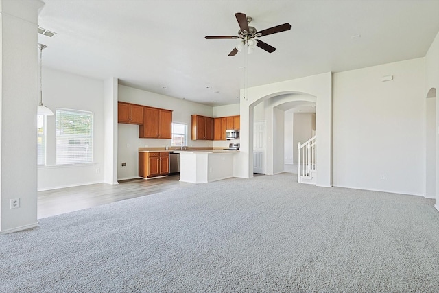 unfurnished living room with ceiling fan and carpet floors