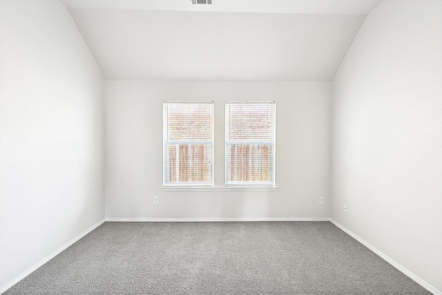 carpeted empty room with lofted ceiling