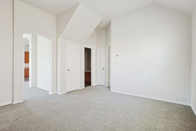 empty room with vaulted ceiling and carpet