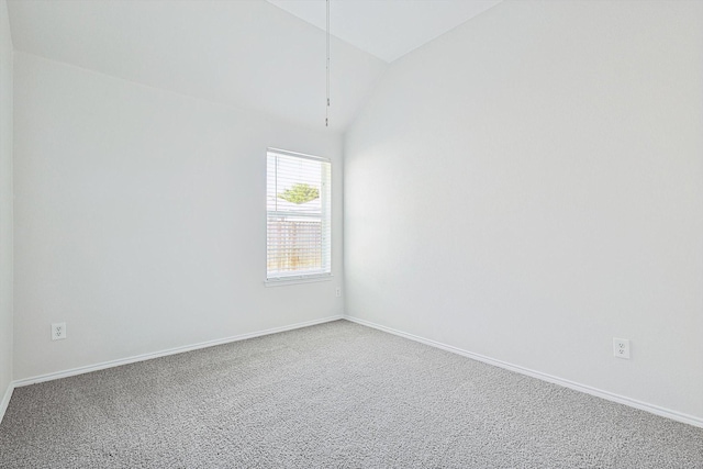 spare room with carpet and vaulted ceiling