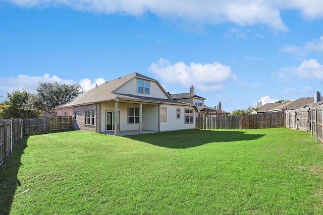 rear view of property with a yard