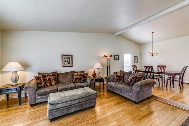 living room featuring light hardwood / wood-style floors, lofted ceiling with beams, and a chandelier